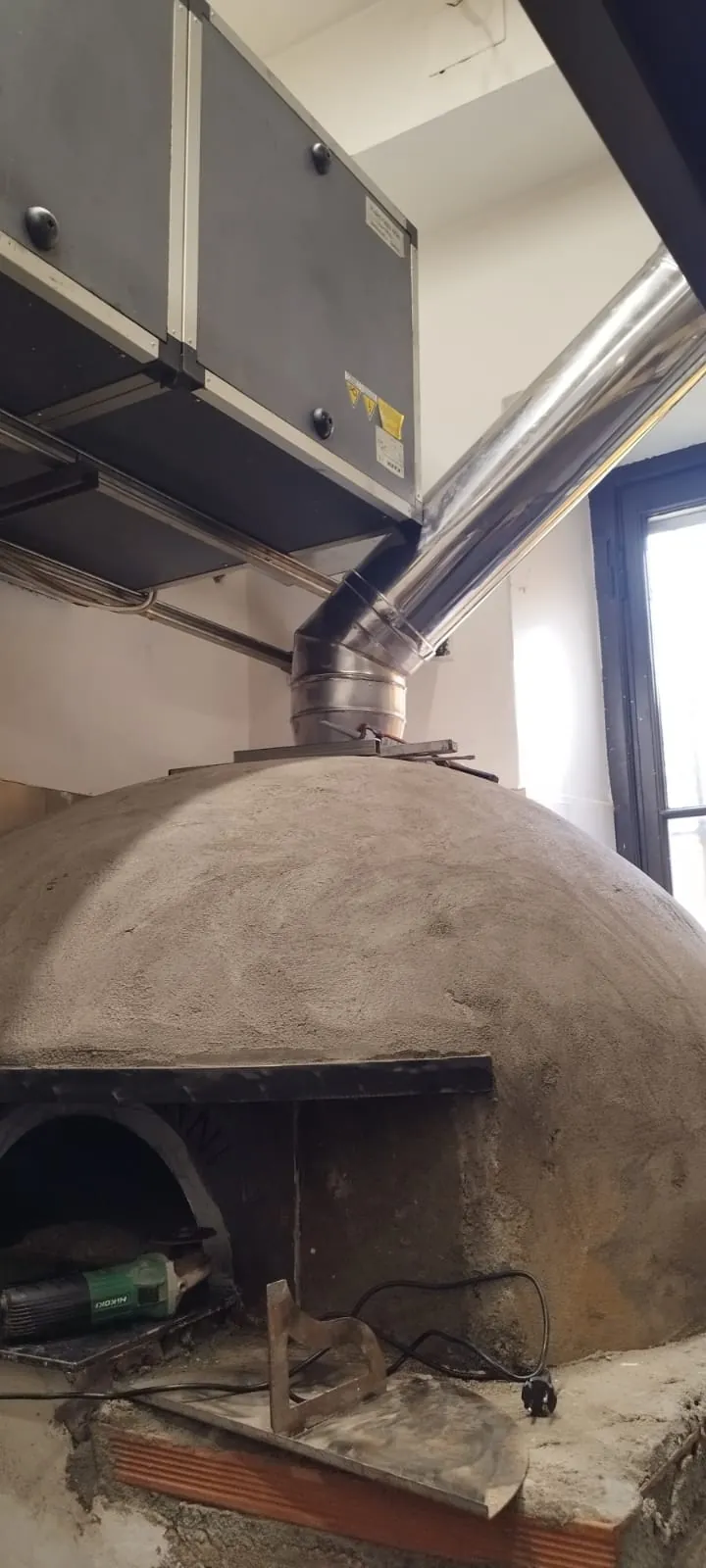 Forno a legna per pizzeria collegato alla canna fumaria in acciaio inox e all'unità di abbattimento fumi