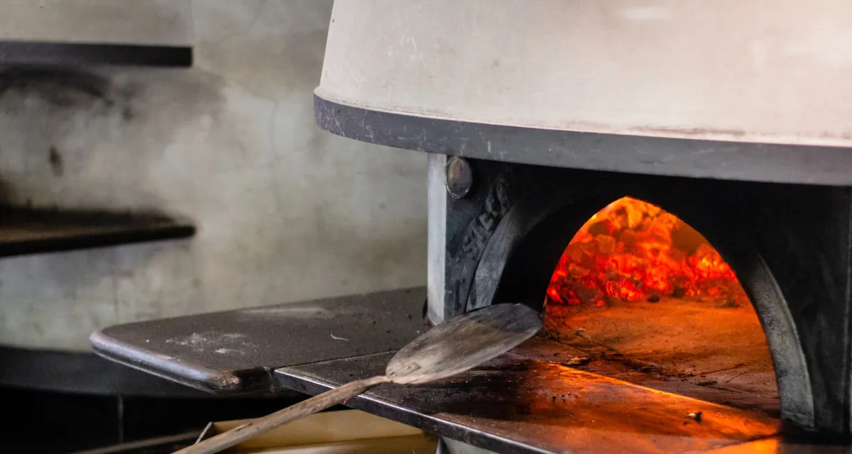 Bocca di un forno a legna per pizza con la brace accesa