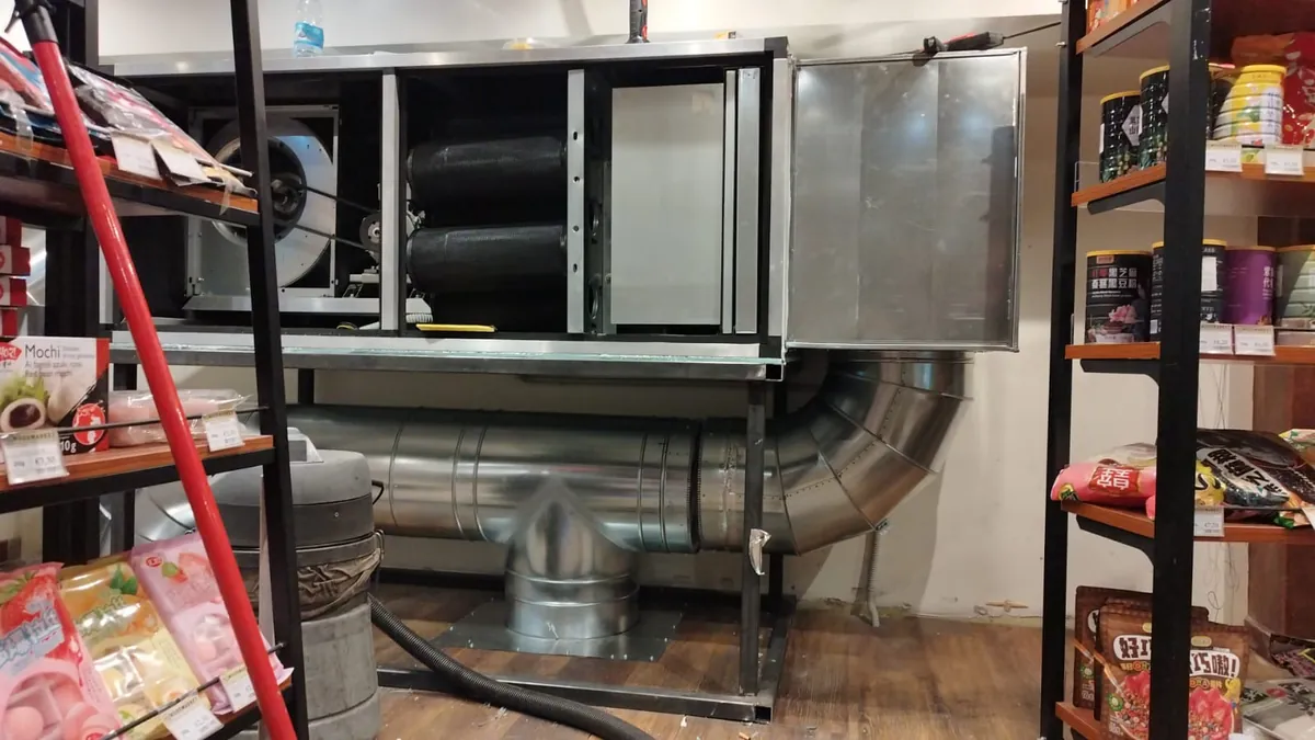 Unità di aspirazione con ventilatore e filtri a carboni attivi collegata ai condotti in acciaio di un locale